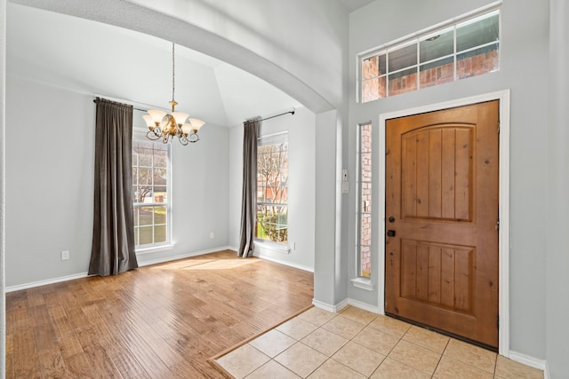 8664 Glenburne Dr, Fort Worth, TX 76131 - entrance foyer featuring arched walkways, baseboards, a notable chandelier, and light wood-style flooring