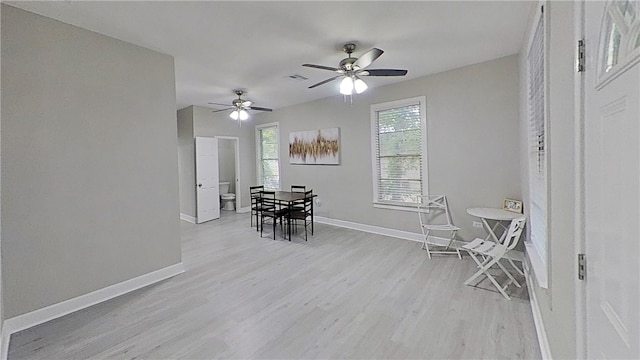 dining space featuring light wood finished floors, baseboards, ceiling fan, and visible vents