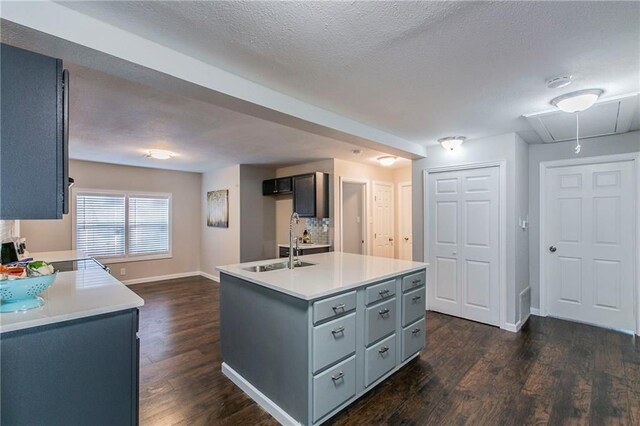 2400 Ethel Ave, Waco, TX 76707 - kitchen featuring dark wood-type flooring, light countertops, gray cabinets, a textured ceiling, and a sink