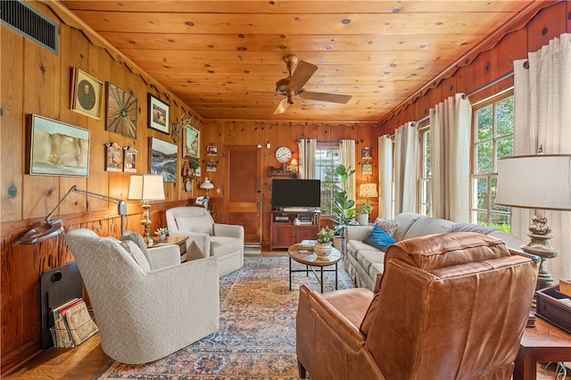 living area featuring wooden walls, visible vents, ceiling fan, wood ceiling, and wood finished floors