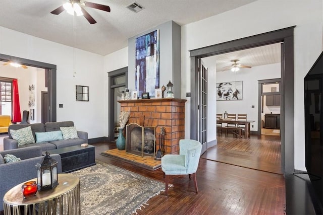 506 E Frederick St, Riesel, TX 76682 - living area featuring visible vents, a fireplace, a ceiling fan, and hardwood / wood-style flooring