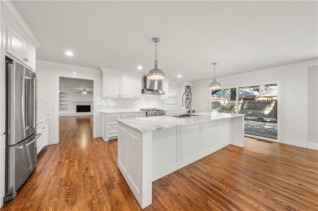 2901 Woodland Dr, Waco, TX 76710 - kitchen featuring dark wood-style floors, a sink, stove, wall chimney range hood, and stainless steel fridge
