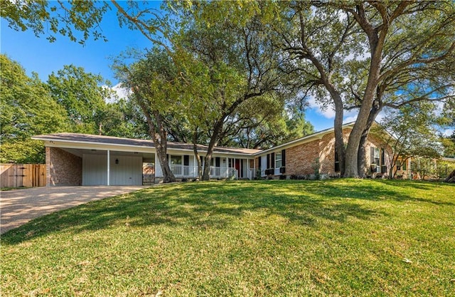 2901 Woodland Dr, Waco, TX 76710 - ranch-style house featuring an attached carport, concrete driveway, fence, and a front yard