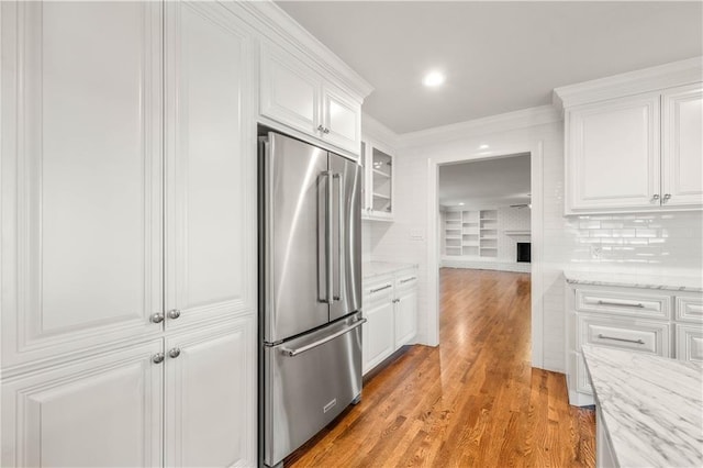 2901 Woodland Dr, Waco, TX 76710 - kitchen with light wood-style floors, high end fridge, and white cabinetry