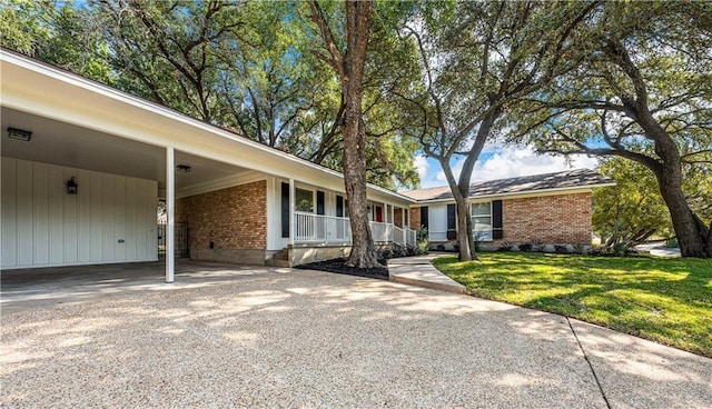 2901 Woodland Dr, Waco, TX 76710 - single story home with brick siding, a front yard, covered porch, a carport, and driveway