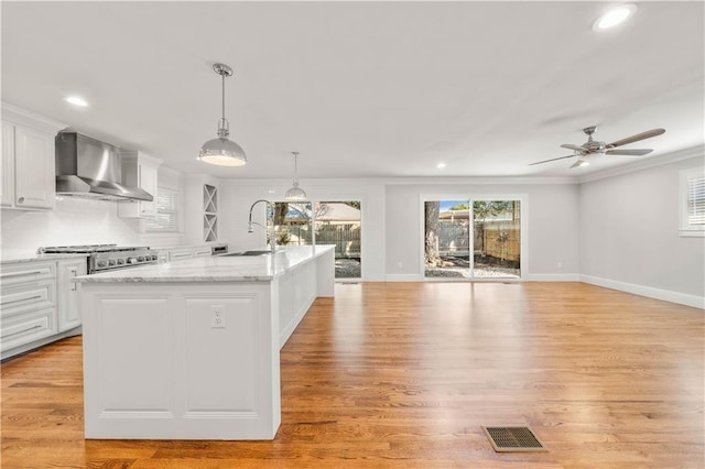 2901 Woodland Dr, Waco, TX 76710 - kitchen featuring visible vents, a sink, white cabinets, wall chimney exhaust hood, and range