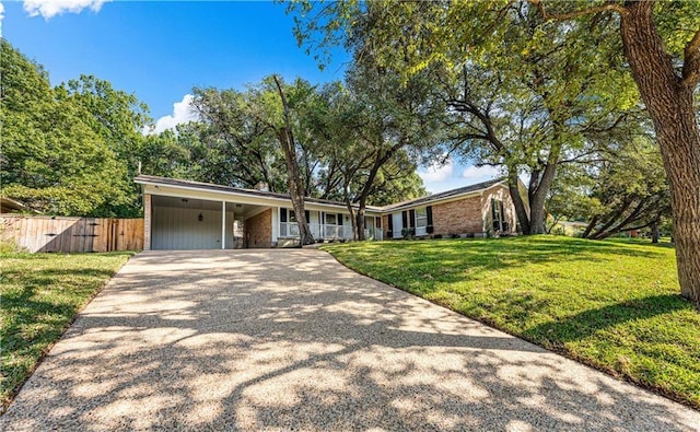 2901 Woodland Dr, Waco, TX 76710 - ranch-style house with a front lawn, concrete driveway, fence, and a carport