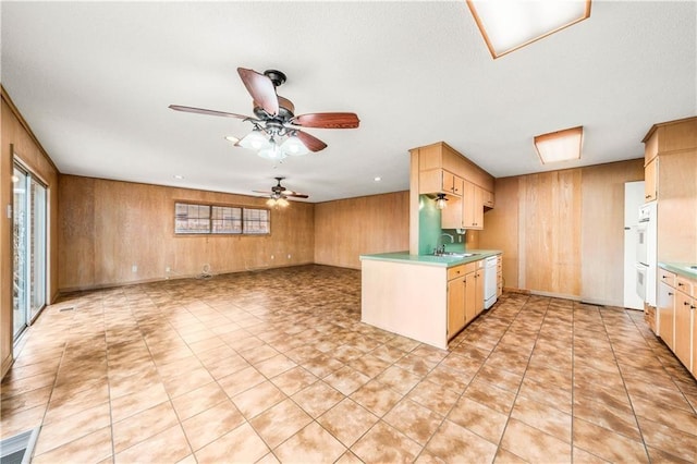 2901 Woodland Dr, Waco, TX 76710 - kitchen with white appliances, ceiling fan, a sink, light countertops, and wood walls