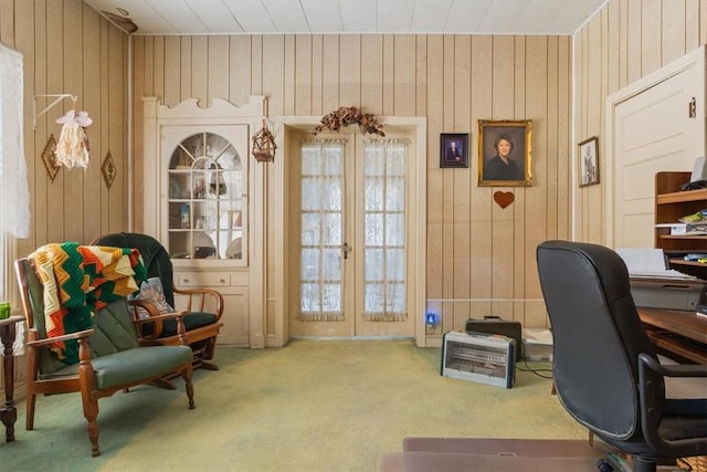 carpeted home office with french doors and wood walls