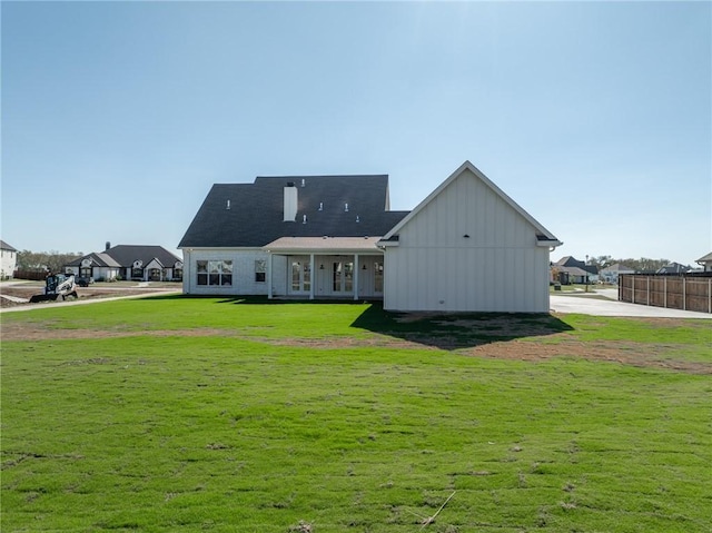 back of house featuring a yard and board and batten siding