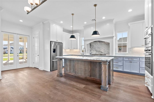 kitchen featuring ornamental molding, a sink, wood finished floors, white cabinetry, and high end refrigerator