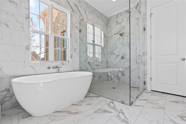 full bath with a freestanding tub, marble finish floor, a marble finish shower, tile walls, and stone wall