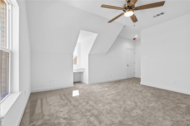 additional living space featuring visible vents, carpet floors, ceiling fan, and vaulted ceiling