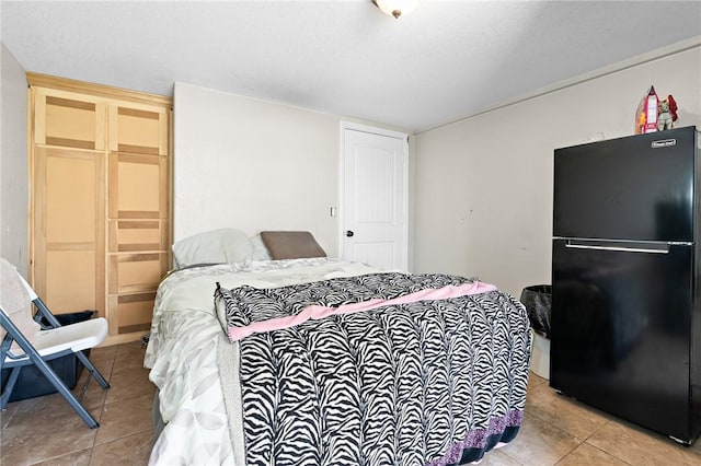 3243 N Lone Star Pkwy, Mcgregor, TX 76657 - bedroom with light tile patterned floors, a closet, and freestanding refrigerator