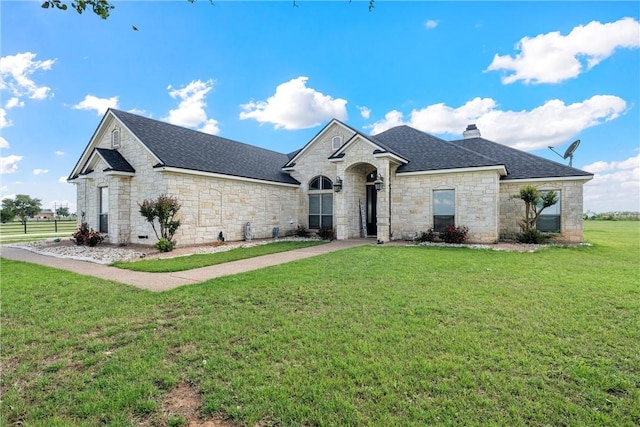 3243 N Lone Star Pkwy, Mcgregor, TX 76657 - french country style house featuring a chimney, stone siding, roof with shingles, and a front yard