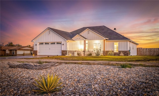view of front of property featuring a front yard, a chimney, concrete driveway, a garage, and board and batten siding