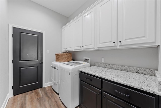 laundry room featuring baseboards, cabinet space, independent washer and dryer, and light wood-type flooring