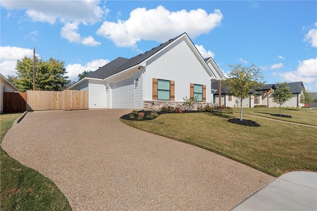 view of side of property featuring fence, concrete driveway, a garage, a lawn, and board and batten siding