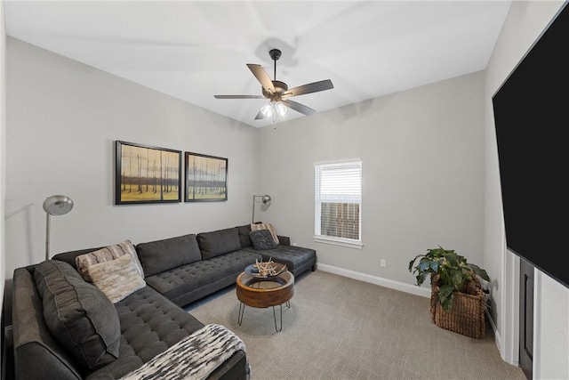 carpeted living room featuring baseboards and ceiling fan