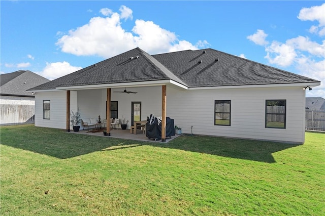 back of property featuring a ceiling fan, fence, a patio area, and a lawn