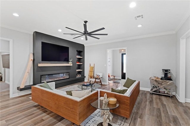 living room featuring built in features, visible vents, wood finished floors, and ceiling fan