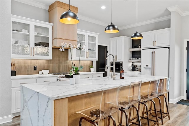 kitchen featuring white cabinets, light wood-style floors, backsplash, and ornamental molding
