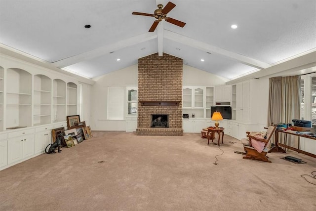 living area featuring a fireplace, lofted ceiling with beams, a ceiling fan, and carpet floors