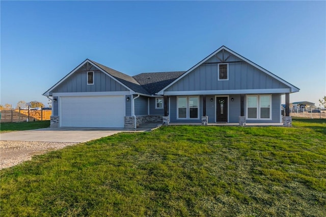 view of front of home with a front yard, fence, driveway, a garage, and board and batten siding