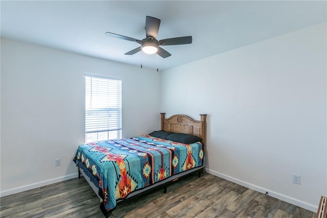 bedroom with a ceiling fan, baseboards, and wood finished floors