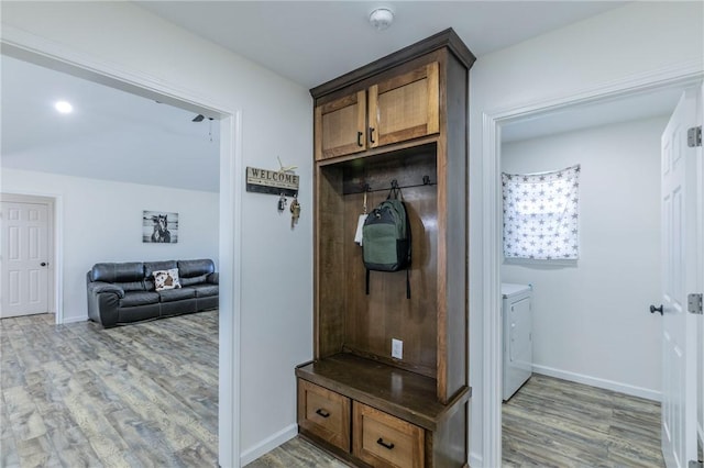 mudroom featuring washer and dryer, baseboards, and light wood-style floors