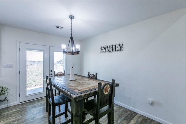 dining room with baseboards, dark wood-type flooring, a notable chandelier, and visible vents