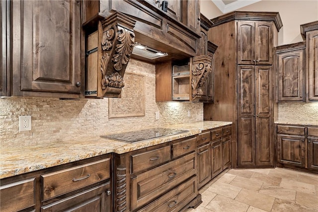 8460 Spicewood Springs Rd, China Spring, TX 76633 - kitchen with stone finish flooring, backsplash, dark brown cabinetry, black electric stovetop, and light stone countertops
