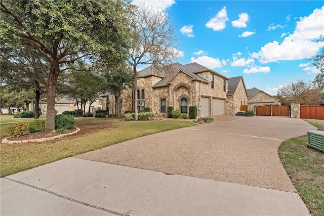 8460 Spicewood Springs Rd, China Spring, TX 76633 - french country home featuring driveway, a gate, stone siding, fence, and a front yard