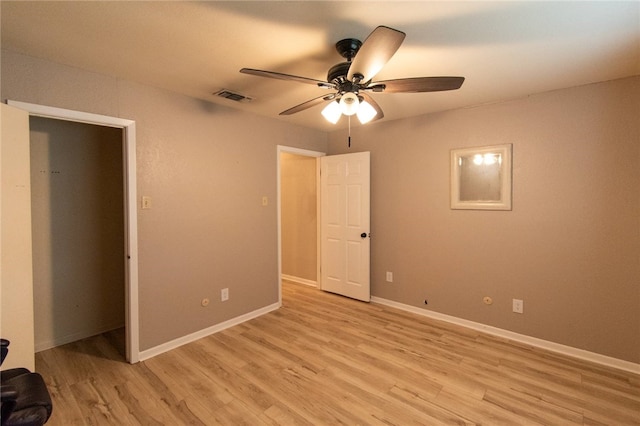 unfurnished bedroom featuring light wood-type flooring, visible vents, baseboards, and ceiling fan