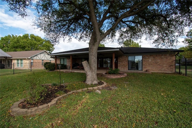 back of property with brick siding, a fenced backyard, a patio, and a yard