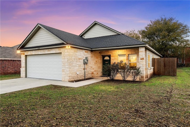 view of front of home with driveway, roof with shingles, an attached garage, a front lawn, and stone siding
