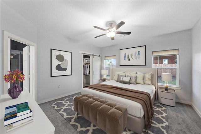 bedroom featuring a barn door, multiple windows, and carpet