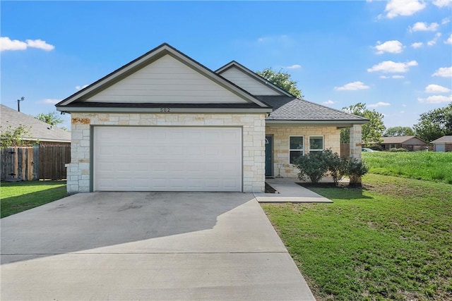 view of front facade featuring a front lawn, fence, concrete driveway, a garage, and stone siding