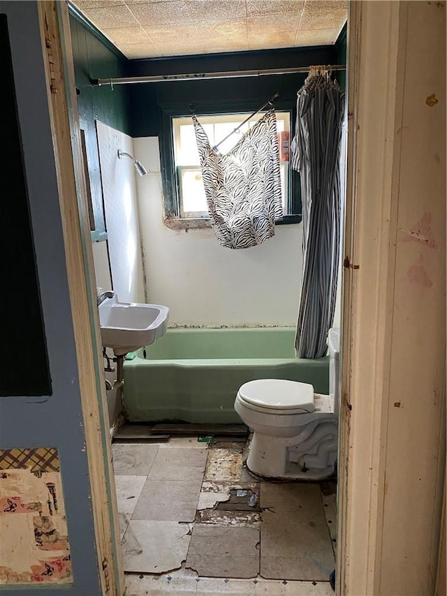 full bath with shower / tub combo, toilet, and a sink