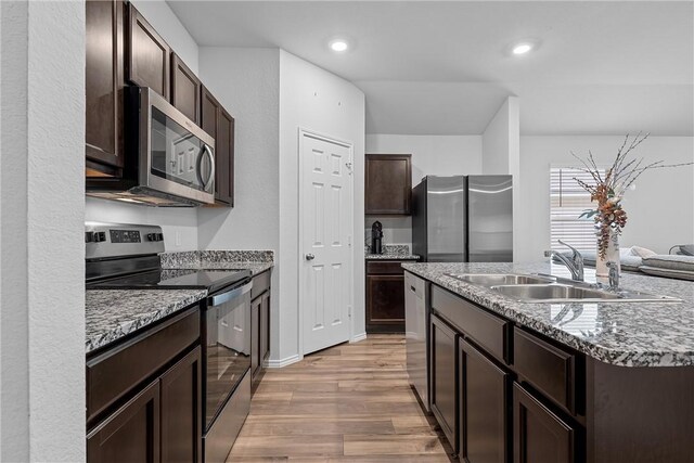 960 Chambray Dr, Troy, TX 76579 - kitchen with light wood-style flooring, an island with sink, a sink, stainless steel appliances, and dark brown cabinets
