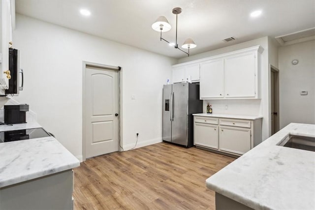 629 S 5th St, Waco, TX 76706 - kitchen featuring visible vents, light wood-style flooring, stainless steel appliances, white cabinets, and pendant lighting