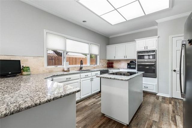 kitchen with backsplash, crown molding, light stone countertops, a sink, and black electric stovetop