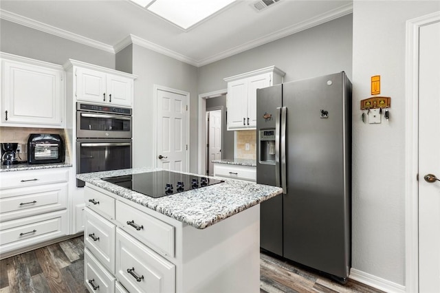 kitchen with ornamental molding, a kitchen island, white cabinets, dark wood finished floors, and stainless steel appliances