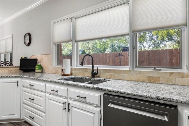 kitchen with light stone counters, a sink, dishwasher, white cabinetry, and decorative backsplash