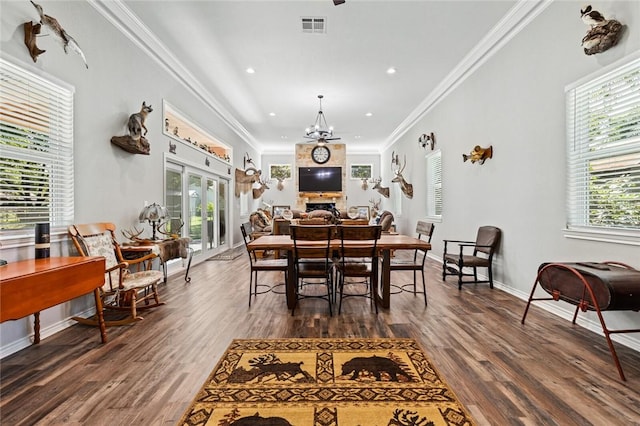 dining room with dark wood-style flooring, a notable chandelier, baseboards, visible vents, and ornamental molding