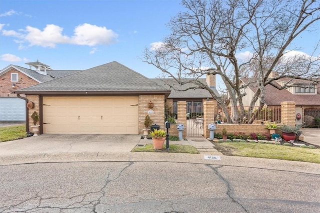 view of front facade featuring a gate, fence, a shingled roof, aphalt driveway, and brick siding