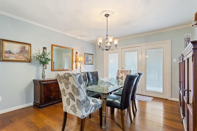dining space with a notable chandelier, crown molding, baseboards, and wood-type flooring