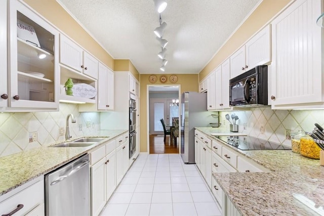 kitchen featuring black appliances, light tile patterned floors, a textured ceiling, white cabinetry, and a sink