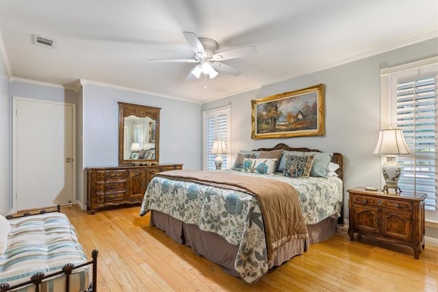 bedroom featuring light wood finished floors, visible vents, ceiling fan, and ornamental molding