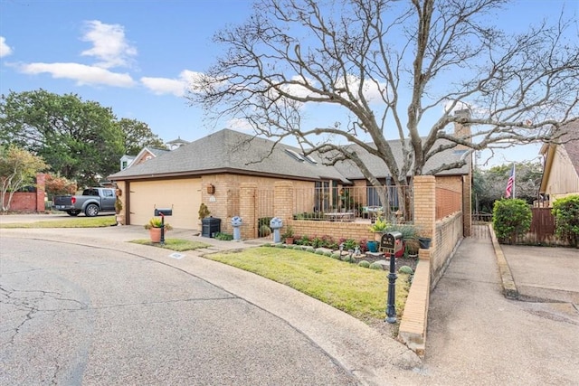 view of front of home featuring a fenced front yard, brick siding, concrete driveway, and an attached garage